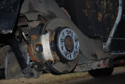 1975 Ford Ranchero - Close-up of a vehicle's rear brake system, showing a caliper, rotor, and a wheel spacer installed.