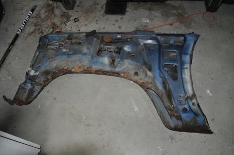 1986 Ford Bronco - This heavily rusted blue fender assembly is a vehicle part, not a complete vehicle.