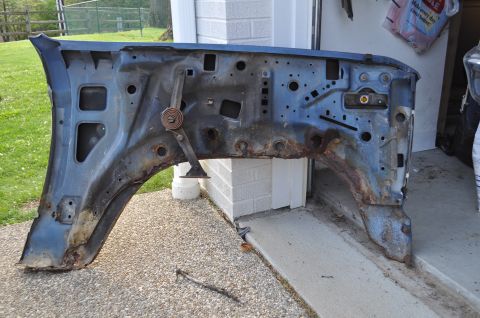 1986 Ford Bronco - A heavily rusted blue fender and inner wheel well structure is shown, with no discernible year or vehicle identification.