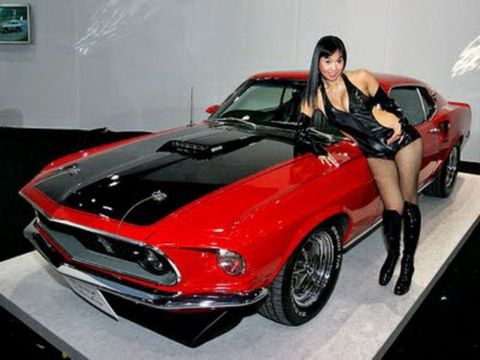 1991 Ford LTD Crown Victoria - A 1969 Ford Mustang Mach 1 is displayed with a model posing next to it.