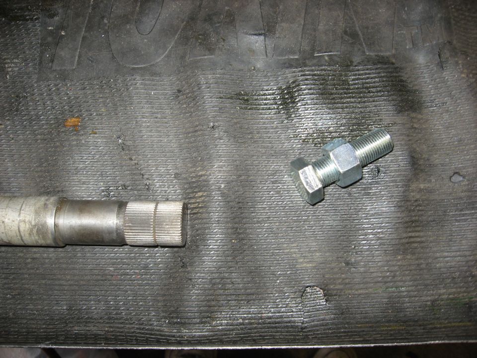 Close-up of a splined shaft next to a bolt with a nut