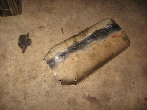 1994 Ford Bronco - A section of an exhaust pipe, showing signs of repair, lies on a concrete surface.