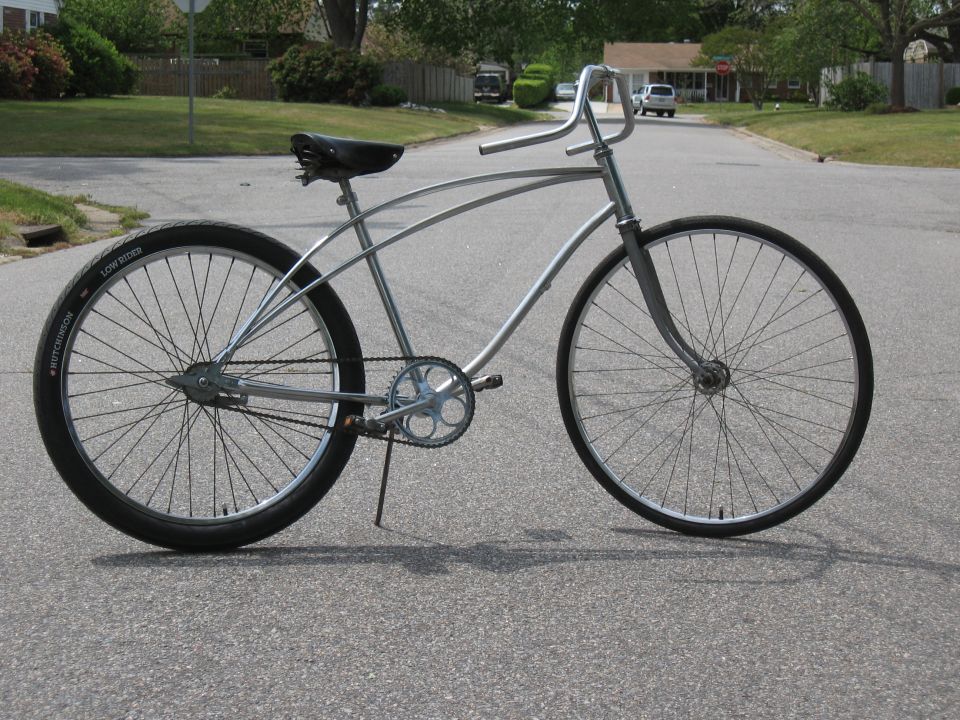 Silver cruiser bicycle with wide handlebars and a black seat
