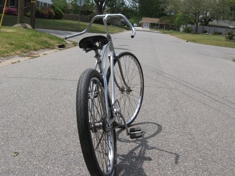 1994 Ford Bronco - Cruiser bicycle with wide handlebars and a black seat parked on a residential street.