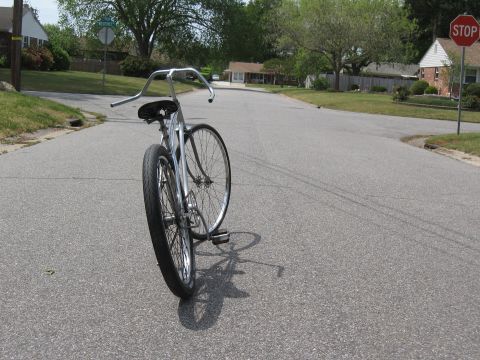 1994 Ford Bronco - A custom cruiser bicycle is parked on a residential street with a stop sign visible in the background.