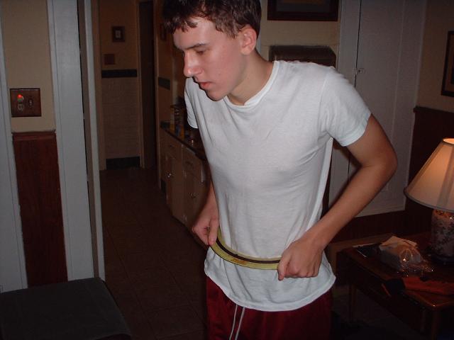 guy in white t-shirt and red shorts pulling up his belt