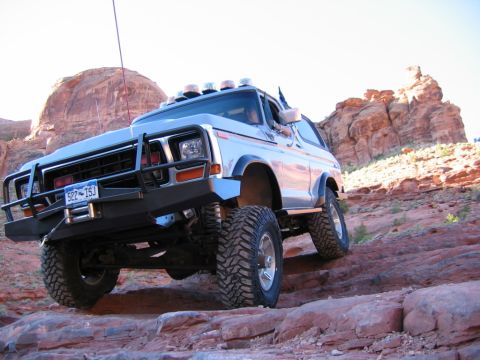 1978 Ford Bronco - This 1978 Ford Bronco is navigating a challenging off-road trail with large rocks and steep inclines.