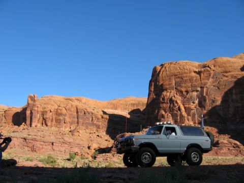 1978 Ford Bronco - A light blue 1978 Ford Bronco is parked in front of large rock formations under a clear blue sky.