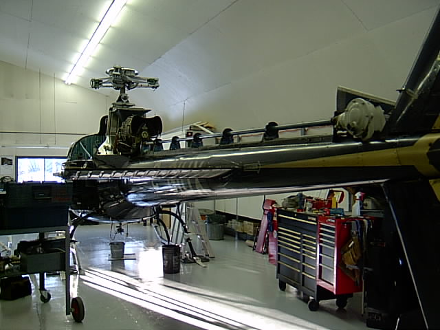 Helicopter in a hangar, side view, with yellow and black stripes