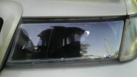 2000 Mercury Grand Marquis - The headlight assembly on this vehicle shows significant cracks and damage to the lens.