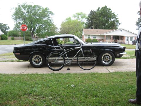 1994 Ford Bronco - A classic black 1967 Ford Mustang GT500 is parked on a driveway with a bicycle positioned in front of it.