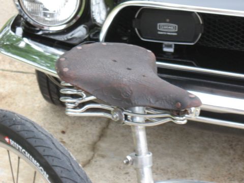 1994 Ford Bronco - A bicycle seat is positioned in front of the grille of a classic car.