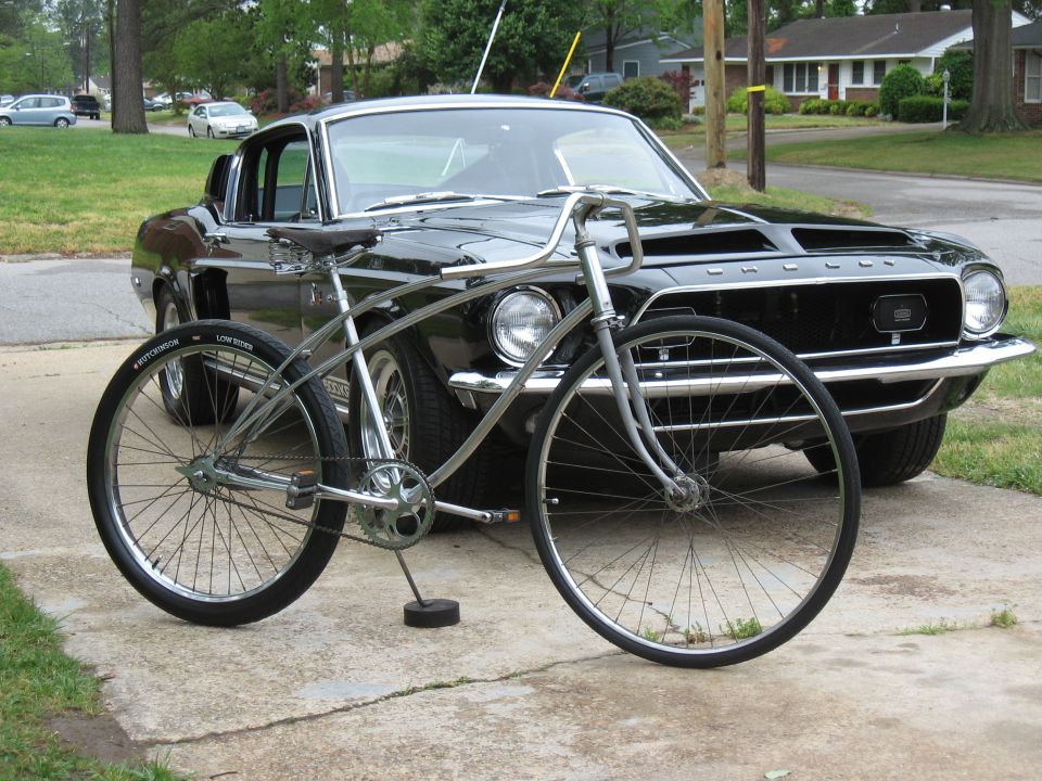 Black 1967 Ford Mustang with a silver bicycle in front