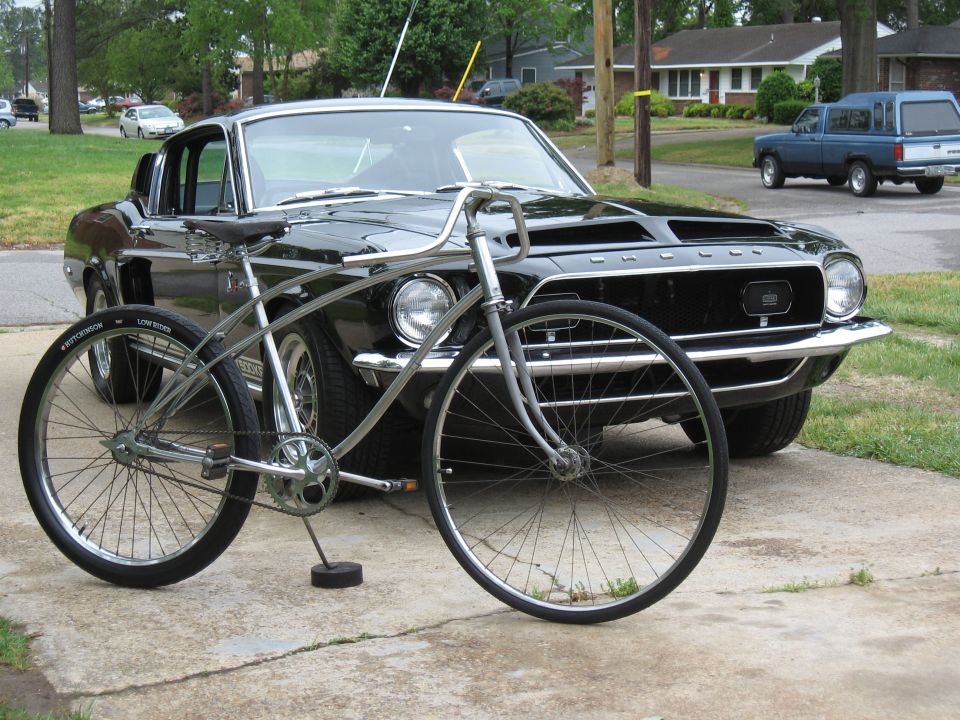 Black 1967 Ford Mustang coupe with vintage bicycle