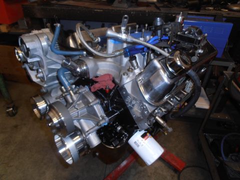 1990 Ford Bronco - A custom V8 engine assembly sits on a stand, a supercharger and various polished components.