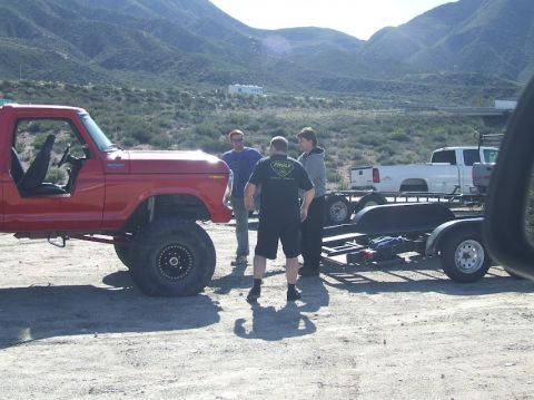 1978 Ford Bronco - 1978 Ford Bronco modified for off-road use, with a trailer and pickup truck in a desert landscape.