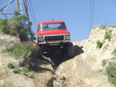 1978 Ford Bronco - Red 1978 Ford Bronco navigating a challenging off-road trail.