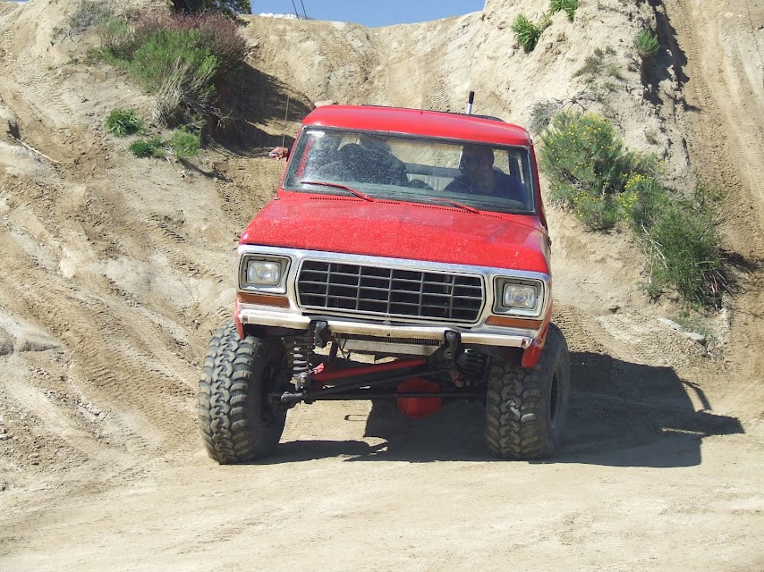 Red 1978 Ford Bronco climbing a dirt hill