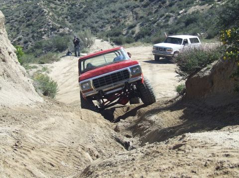 1978 Ford Bronco - Two Ford Broncos navigating a steep, sandy off-road trail.