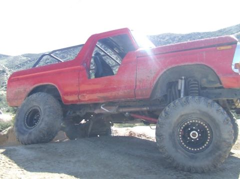 1978 Ford Bronco - Modified 1978 Ford Bronco with off-road tires and suspension, seen on a dirt trail.