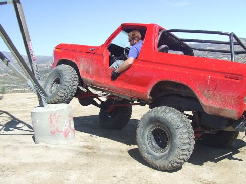 1978 Ford Bronco - 1978 Ford Bronco navigating an obstacle course with its front tire on a concrete block.