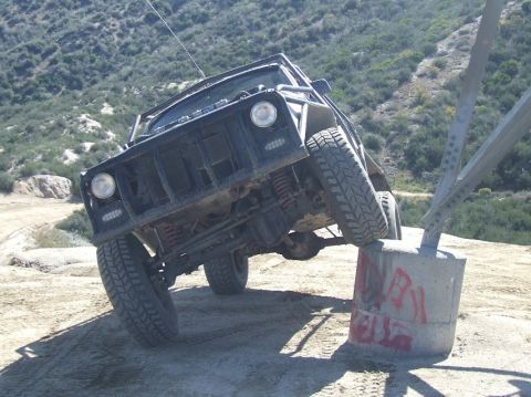 1978 Ford Bronco - This heavily modified off-road vehicle is navigating a challenging obstacle on a dirt terrain.
