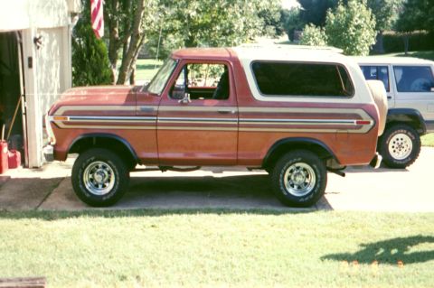 1979 Ford Bronco - Side view of a red and white 1979 Ford Bronco parked in a driveway.
