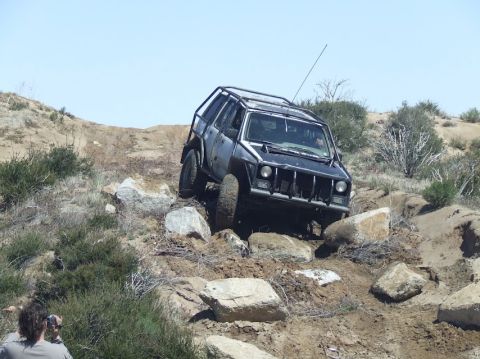 1978 Ford Bronco - Modified off-road vehicle tackling a challenging rocky incline.