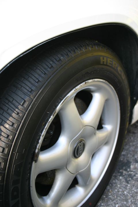 1997 Volvo 850 - Close-up of a 1997 Volvo 850 wheel and tire, showing the distinctive five-spoke alloy design and the Volvo emblem on the center cap.