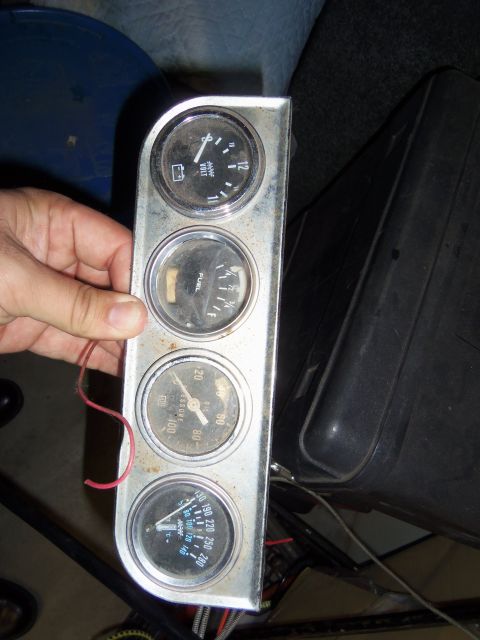 1968 Ford Bronco - Gauge cluster with voltmeter, fuel, oil pressure, and temperature gauges. Voltmeter reads around 11-12V.