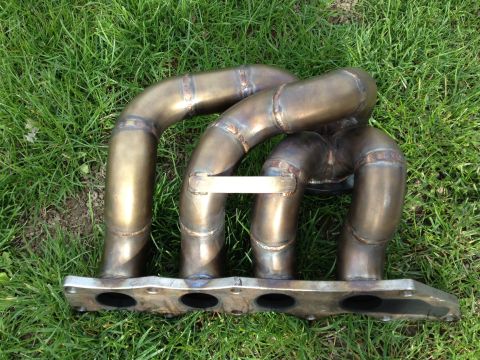 1987 Ford Bronco - Custom exhaust manifold with four pipes merging into one, bolted to a flange with four openings.