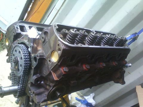 1989 Ford Bronco - Engine block assembly with timing chain and valve springs exposed, likely during a rebuild or repair process.