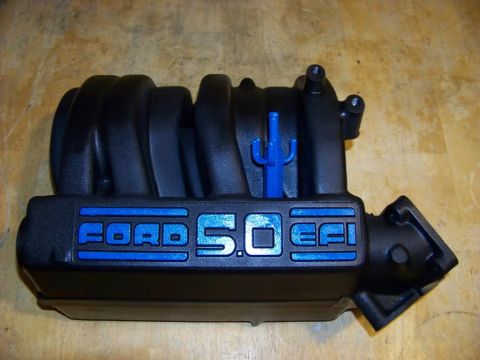 1989 Ford Bronco - A black Ford 5.0 EFI intake manifold is shown, with blue lettering indicating the engine size and fuel injection system.