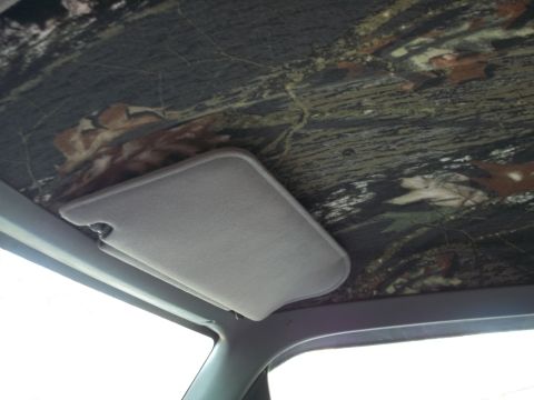1989 Ford Bronco - Vehicle interior shows a camouflage headliner and a gray sun visor.