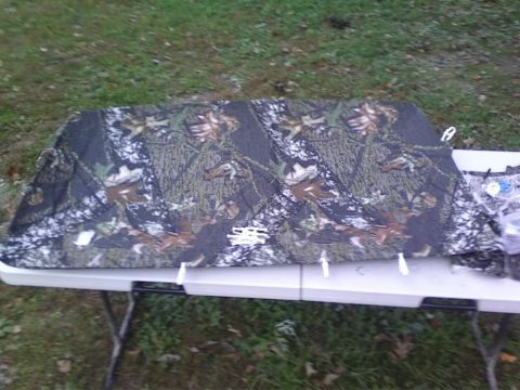 1989 Ford Bronco - Camouflage fabric is spread across a table, with grass and trees in the background.