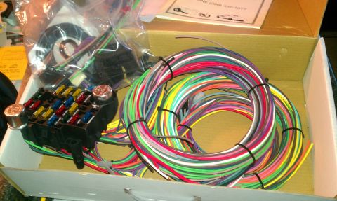 1969 Ford F-250 - A new wiring harness kit with a fuse block and many colorful wires is shown inside its box.