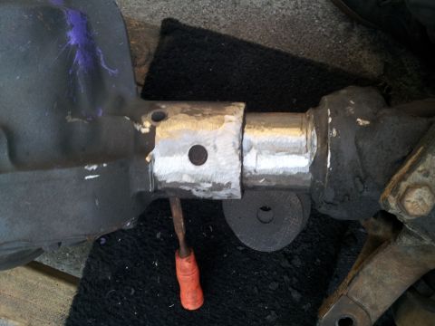1978 Ford Bronco - A close-up view shows a modified axle housing with evidence of recent metalwork and a tool resting on the surface.