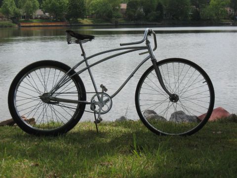 1994 Ford Bronco - A vintage-style bicycle with a metallic finish sits on a grassy bank overlooking a body of water.