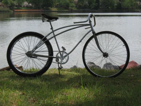 1994 Ford Bronco - A classic-style bicycle with a chrome frame and wide tires rests on the grassy shore of a lake.