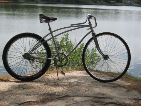 1994 Ford Bronco - A vintage-style cruiser bicycle sits on a sandy path next to a body of water.