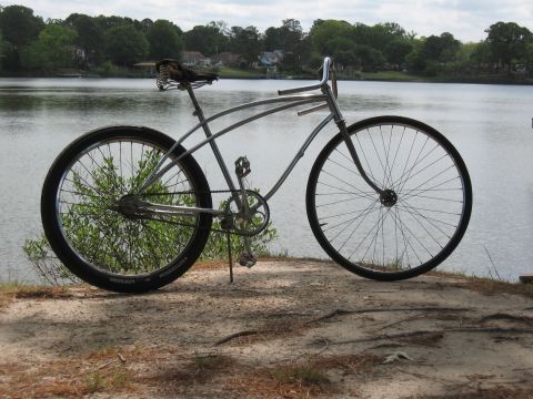 1994 Ford Bronco - A vintage-style silver cruiser bicycle rests on a sandy shore next to a calm lake.