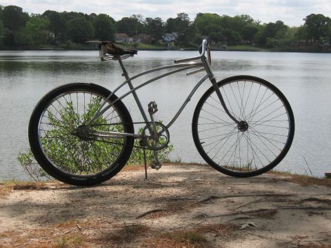 1994 Ford Bronco - Cruiser bicycle with chrome handlebars and a spring-loaded seat sits by the water.