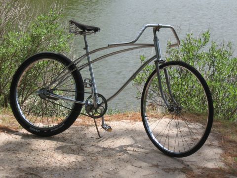 1994 Ford Bronco - A vintage bicycle with a chrome frame and black tires sits on a sandy path next to a body of water.