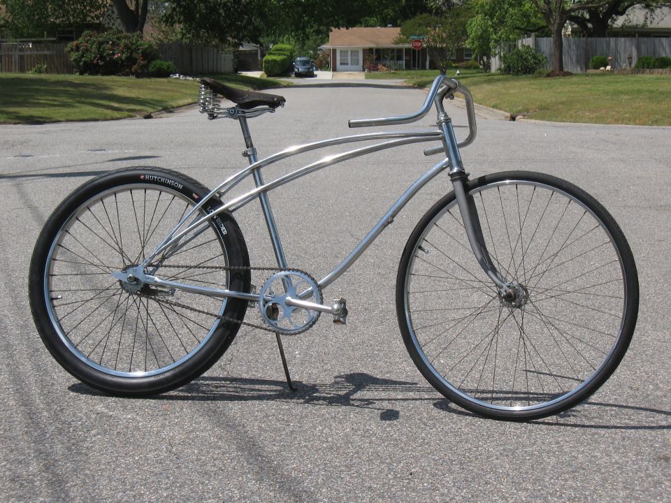 Chrome cruiser bicycle with a brown leather seat and wide handlebars