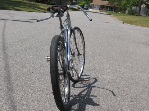 1994 Ford Bronco - This custom bicycle features a chrome frame, wide handlebars, and a sprung seat, presented from a rear-facing perspective.