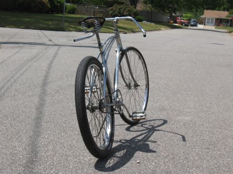 1994 Ford Bronco - Cruiser bicycle with chrome frame and wide handlebars sits on a street.