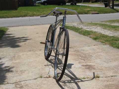 1994 Ford Bronco - A vintage-style cruiser bicycle with a shiny chrome frame and tall handlebars is parked on a concrete driveway.