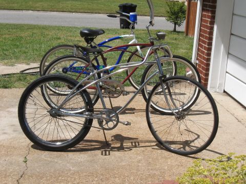 1994 Ford Bronco - Two cruiser bicycles are parked on a driveway next to a brick wall and siding.