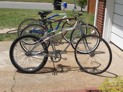 1994 Ford Bronco - A pair of vintage-style bicycles are parked side-by-side on a paved surface in front of a building.