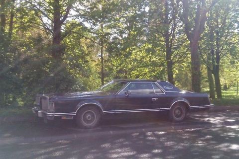 1991 Ford LTD Crown Victoria - Side view of a dark blue Lincoln Continental Mark VI from the early 1980s.